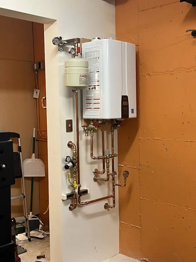 Plumbing technician inspecting water heater connections in Brookland
